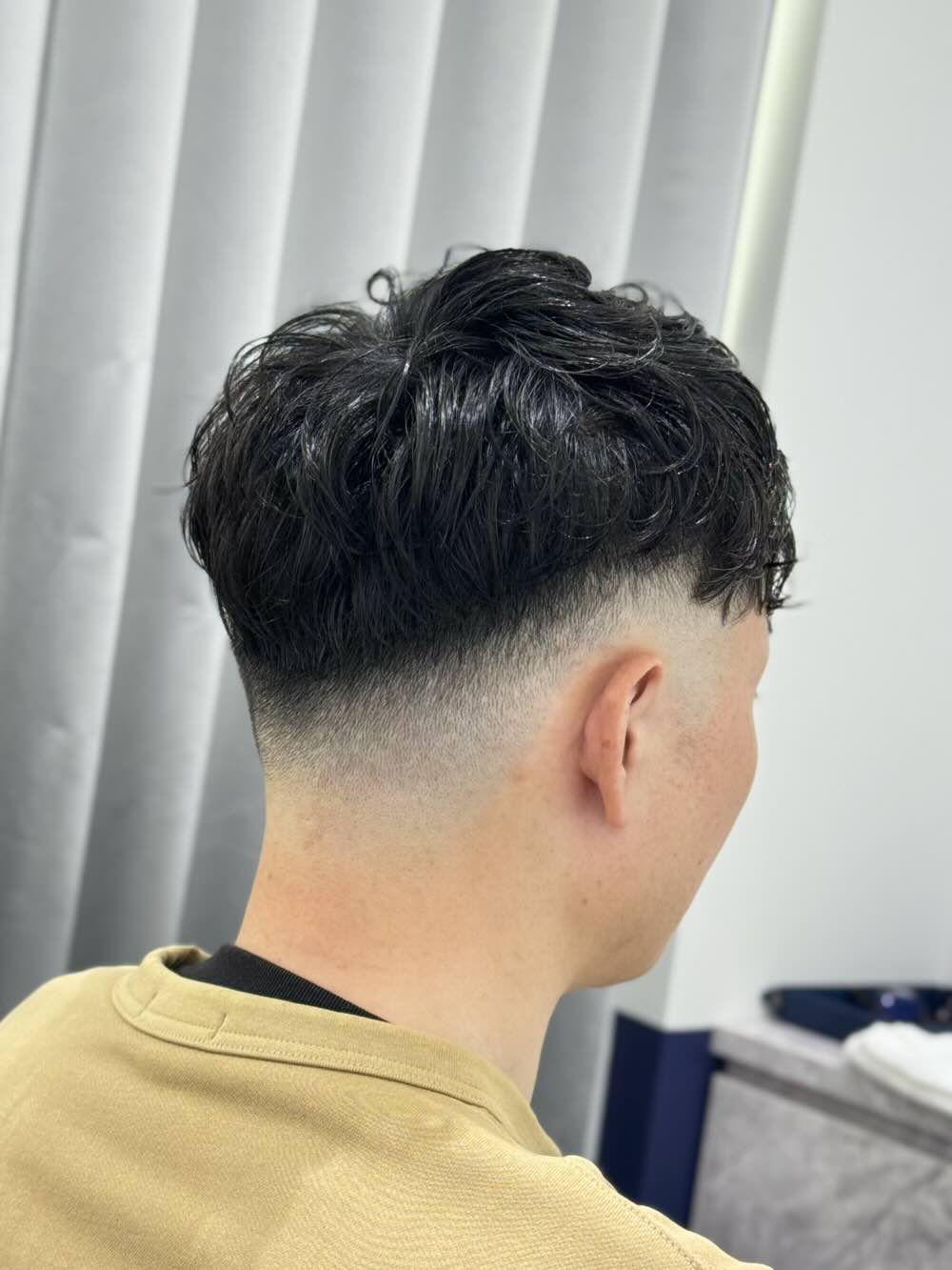 右斜め後ろから見た、クセをやや弱めるコテパーマとフェードの仕上がり